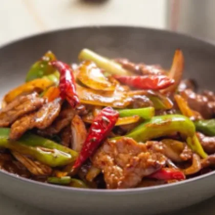 Sliced beef stir-fried with green peppers, onion and dried red chilies in a dark wok sauce at Bao Express