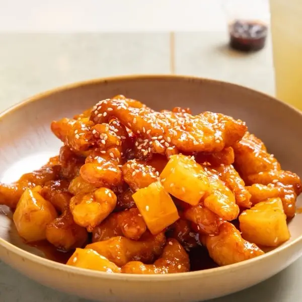Sweet and sour chicken with pineapple in a glossy red sauce