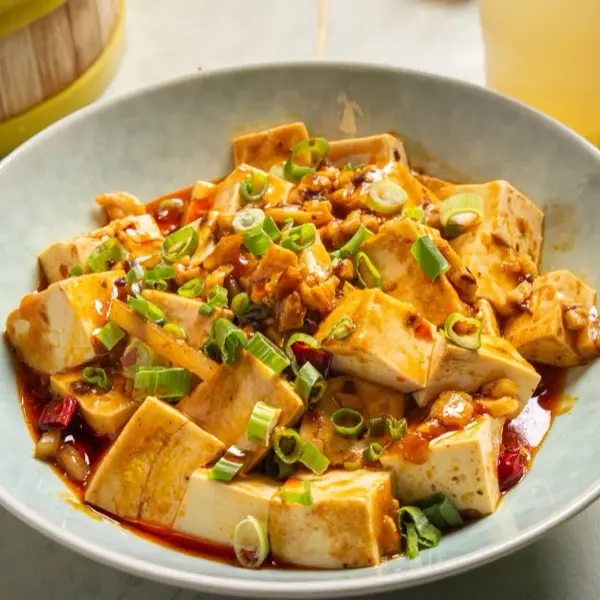 Mapo tofu simmered in chili oil and topped with fresh spring onion