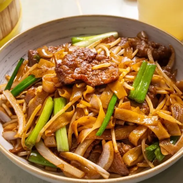 Beef chow fun with wide rice noodles, bean sprouts and spring onion
