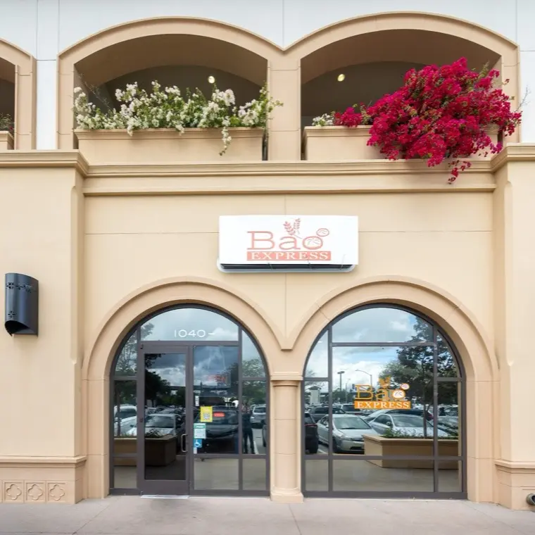 The Bao Express storefront entrance on Park Place in San Mateo with arched windows and bougainvillea